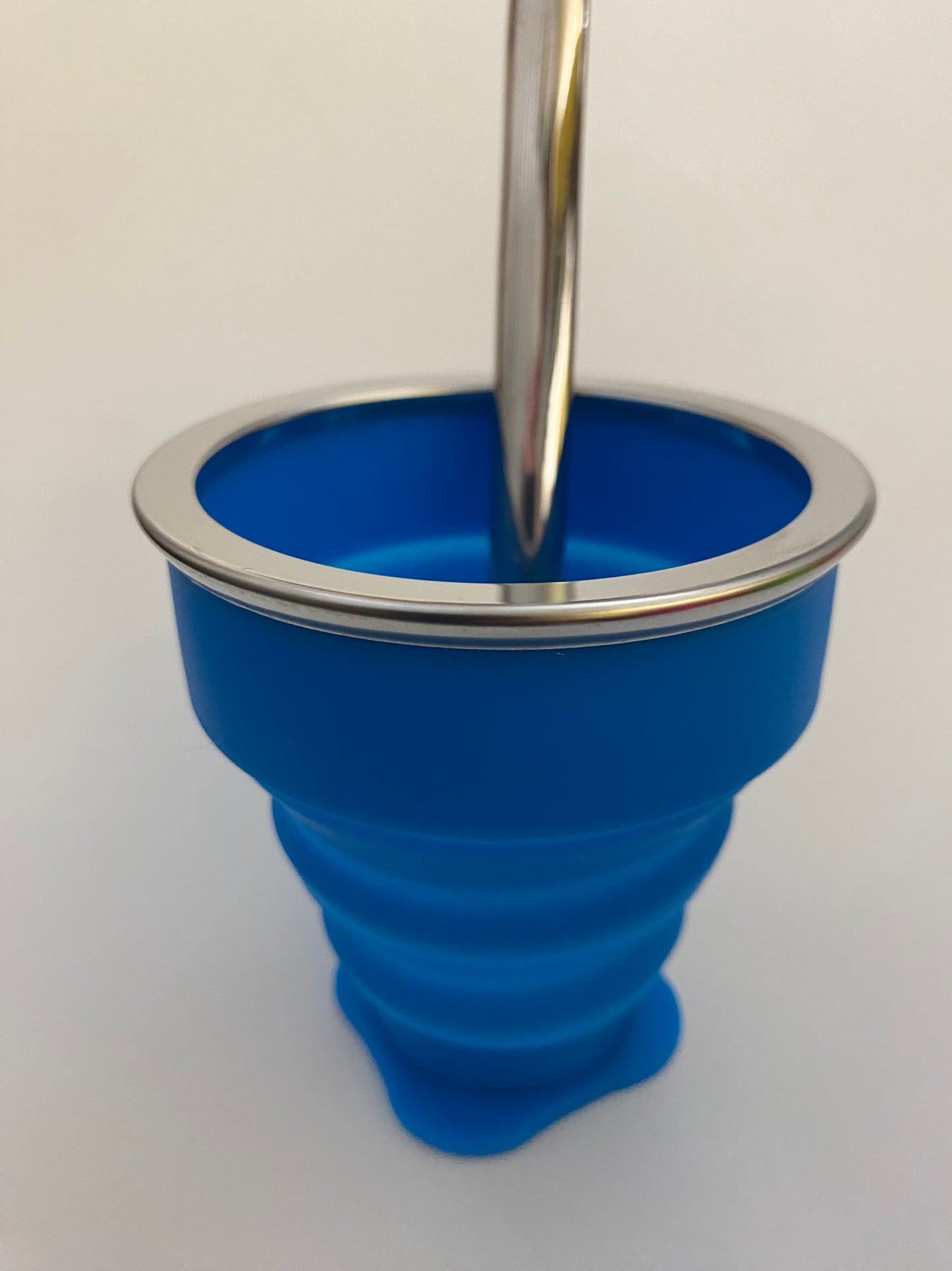 A blue silicone yerba mate gourd with a metallic rim, likely used for serving or drinking mate.