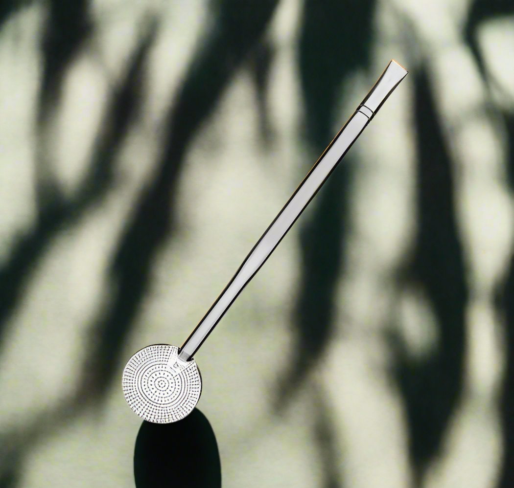 A stainless steel bombilla (chimarráo) with a large number of holes, featuring a rounded end with a loop for hanging.