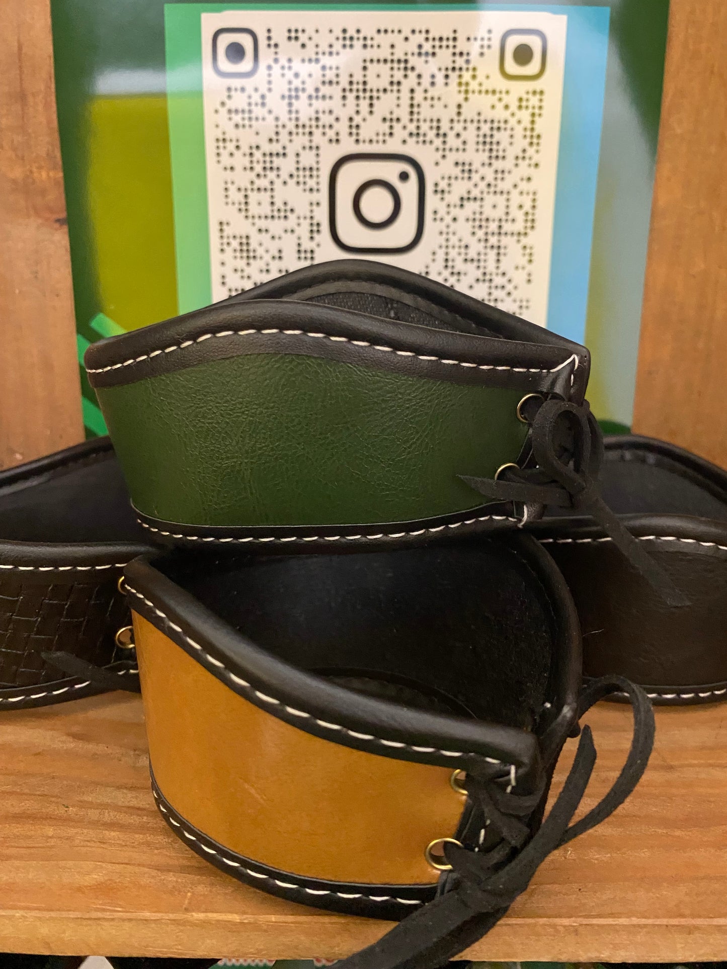 Two leather gourd holders  on a wooden surface with a QR code in the background.