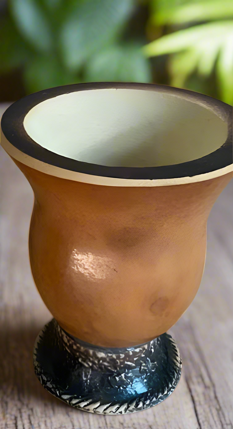 A yerba mate gourd with a textured base on a wooden surface