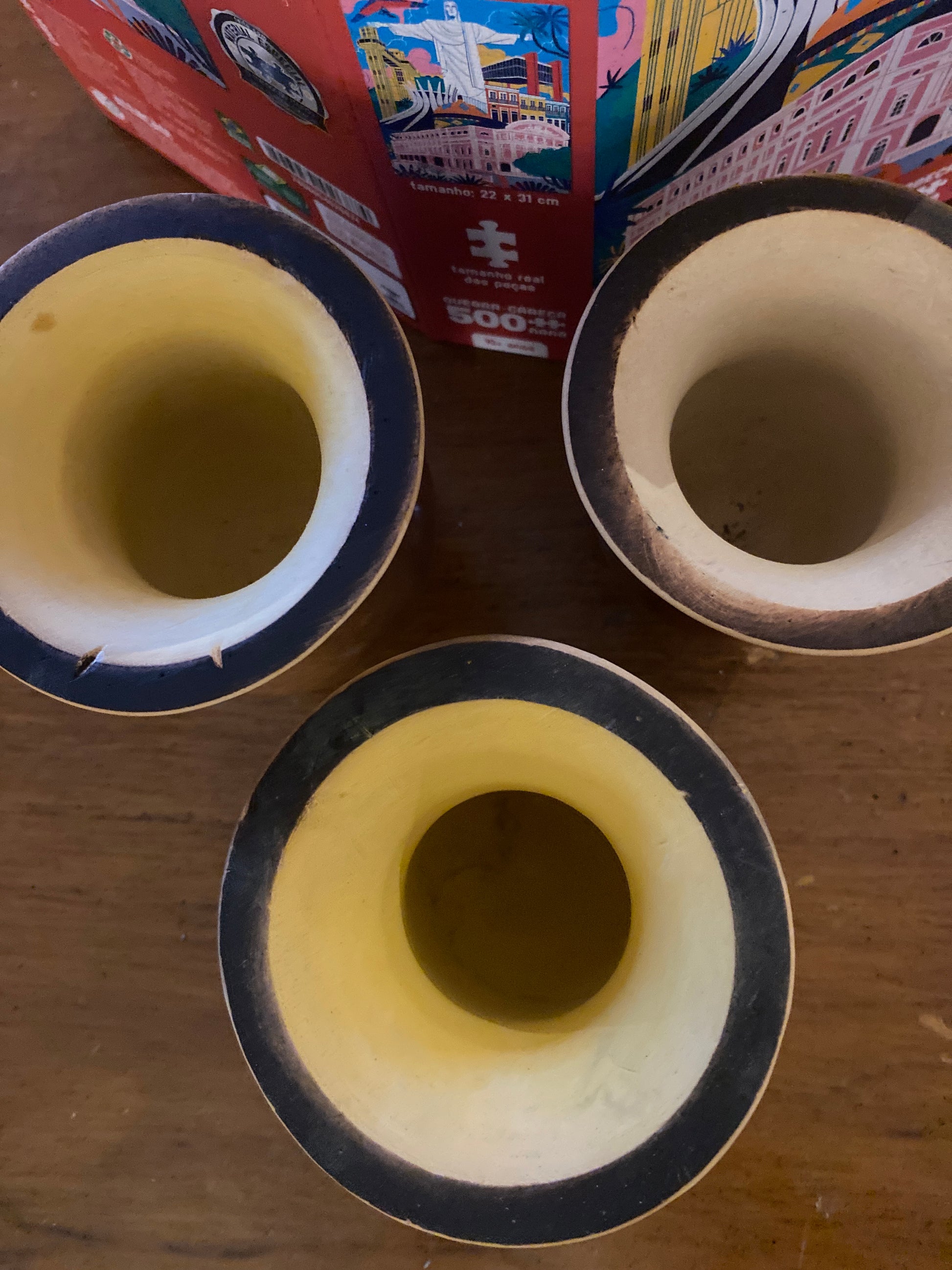 Top view of three yerba mate gourds  on a wooden surface.
